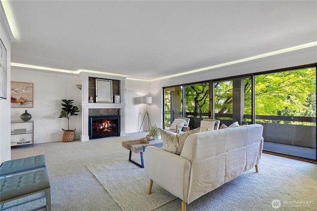 living area featuring a glass covered fireplace and carpet flooring