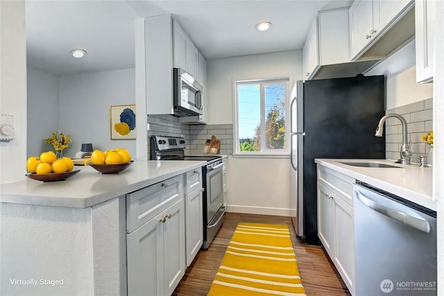 12429 NE 130th Ct Unit G201, Kirkland, WA 98034 - kitchen with a sink, stainless steel appliances, tasteful backsplash, dark wood-type flooring, and baseboards