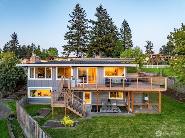 rear view of property with a fenced backyard, a yard, stairway, and a deck