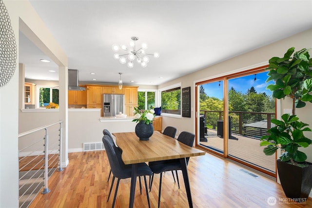 dining space with visible vents, recessed lighting, light wood finished floors, and an inviting chandelier