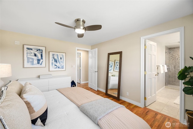 bedroom featuring a ceiling fan, baseboards, ensuite bath, and light wood-style floors