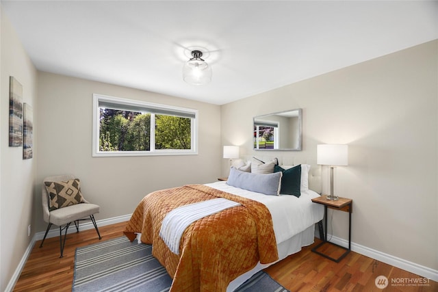 bedroom with baseboards and wood finished floors