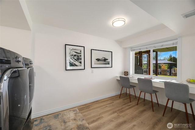 dining area featuring washing machine and clothes dryer, baseboards, visible vents, and wood finished floors