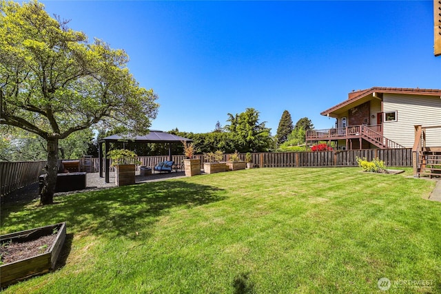 view of yard featuring a gazebo, a fenced backyard, a garden, and stairway