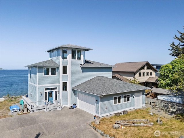 view of front of house with roof with shingles, a water view, and driveway