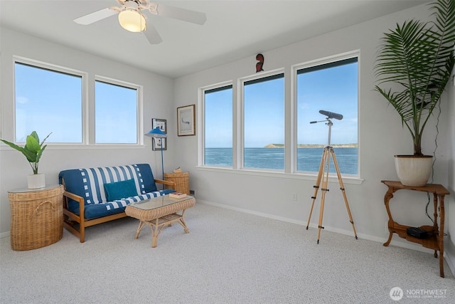 living area featuring carpet floors, a water view, and plenty of natural light