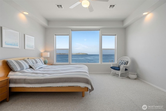 bedroom featuring baseboards, a water view, carpet floors, and visible vents
