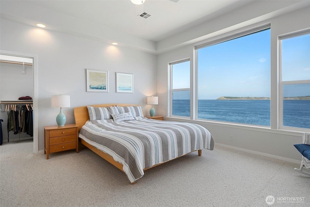 bedroom featuring visible vents, baseboards, carpet floors, and a water view