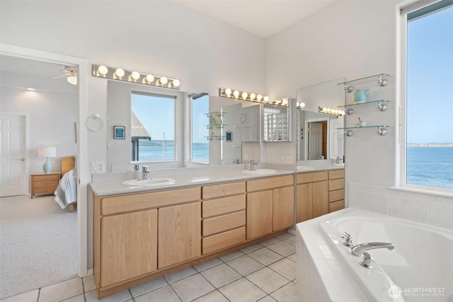 full bathroom with double vanity, a sink, connected bathroom, and plenty of natural light
