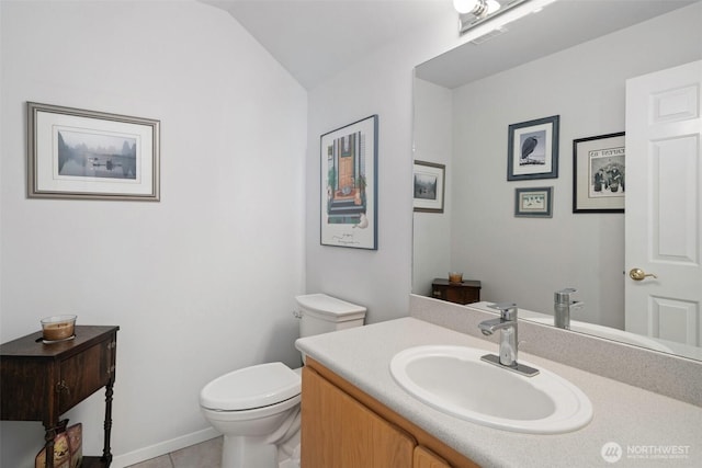 half bath featuring toilet, lofted ceiling, tile patterned floors, and vanity