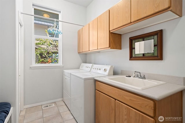 washroom with cabinet space, a sink, separate washer and dryer, baseboards, and visible vents