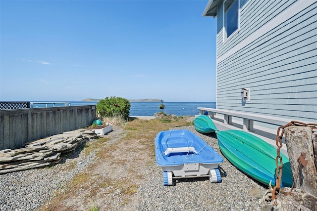 view of yard featuring fence and a water view