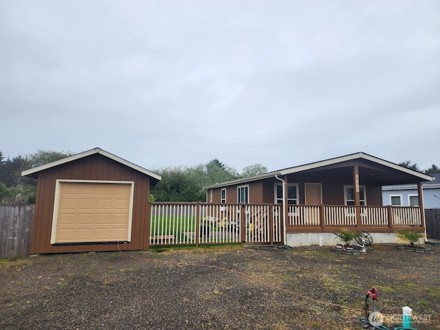 view of front facade with a garage, fence, and an outbuilding