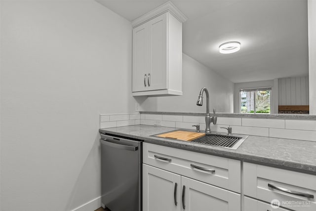 kitchen with stainless steel dishwasher, a sink, baseboards, and white cabinets