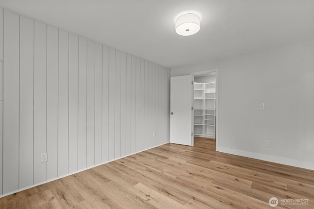 unfurnished room featuring baseboards and light wood finished floors