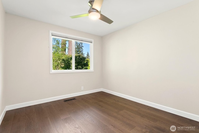 unfurnished room featuring baseboards, a ceiling fan, dark wood-style floors, and visible vents
