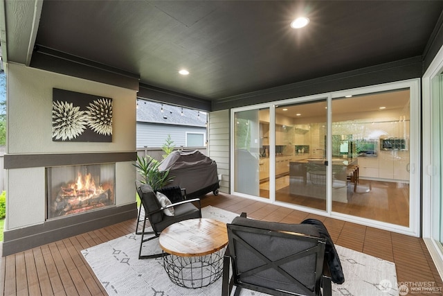 wooden terrace with a glass covered fireplace