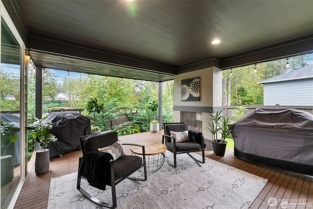 sunroom featuring an outdoor fireplace and a healthy amount of sunlight
