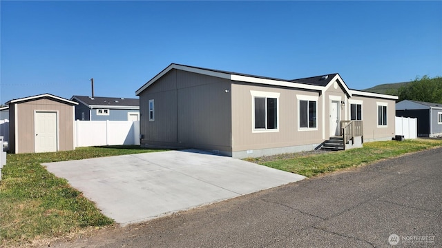 manufactured / mobile home with a storage unit, fence, an outbuilding, and crawl space