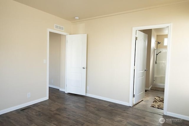 unfurnished bedroom featuring visible vents, baseboards, and dark wood-style floors