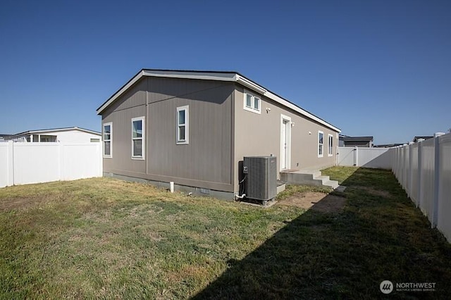 view of property exterior with central air condition unit, a yard, and a fenced backyard