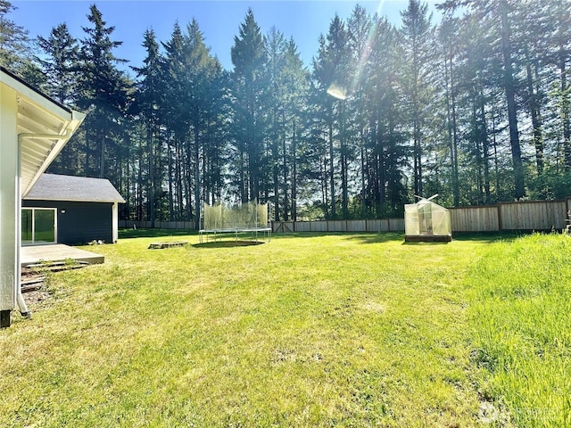 view of yard with a fenced backyard and a trampoline