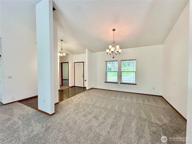 carpeted spare room with an inviting chandelier, baseboards, and lofted ceiling