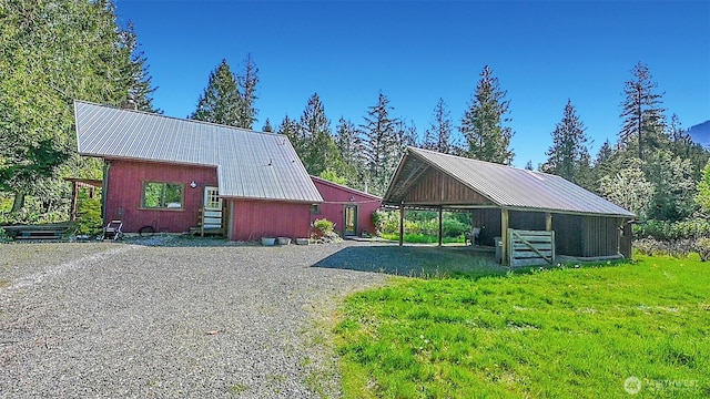 exterior space with a barn, a carport, and gravel driveway