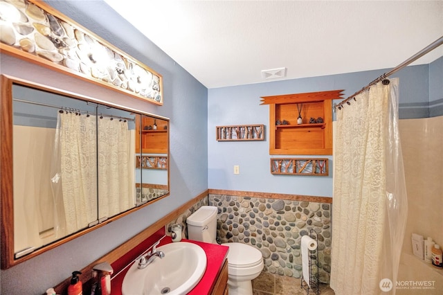 full bathroom featuring visible vents, vanity, wainscoting, toilet, and a shower with curtain