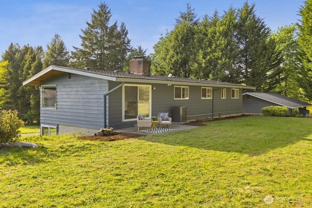 10121 Crescent Valley Dr NW, Gig Harbor, WA 98332 - rear view of property featuring a chimney, central AC, a lawn, and a patio