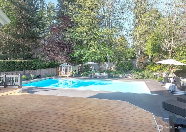 view of pool with an outbuilding, a wooden deck, a fenced in pool, an outdoor hangout area, and a fenced backyard