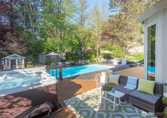 view of pool featuring a hot tub, a fenced in pool, a wooden deck, and a fenced backyard