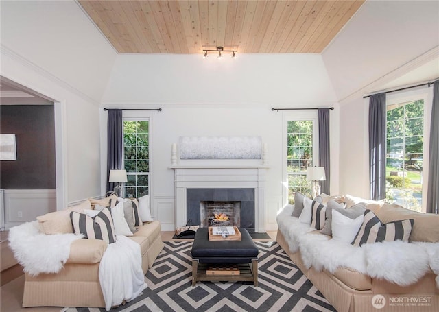 living room featuring a fireplace with flush hearth, wood ceiling, lofted ceiling, and a healthy amount of sunlight