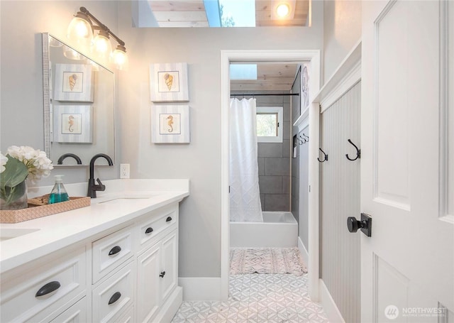full bath featuring double vanity, baseboards, a sink, and shower / bath combo with shower curtain