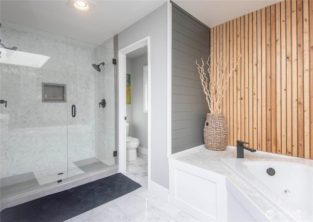 bathroom with a stall shower, marble finish floor, wood walls, and toilet