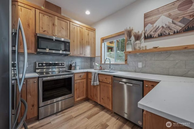 41 Hawkeye, Ronald, WA 98940 - kitchen featuring light wood-style flooring, appliances with stainless steel finishes, a sink, and tasteful backsplash