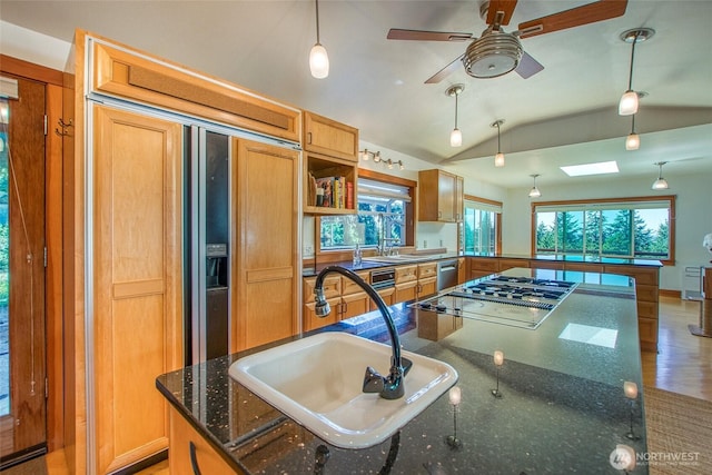 97 Snowberry Ln, Orcas Island, WA 98245 - kitchen featuring vaulted ceiling, stovetop with downdraft, a ceiling fan, dark stone countertops, and a skylight