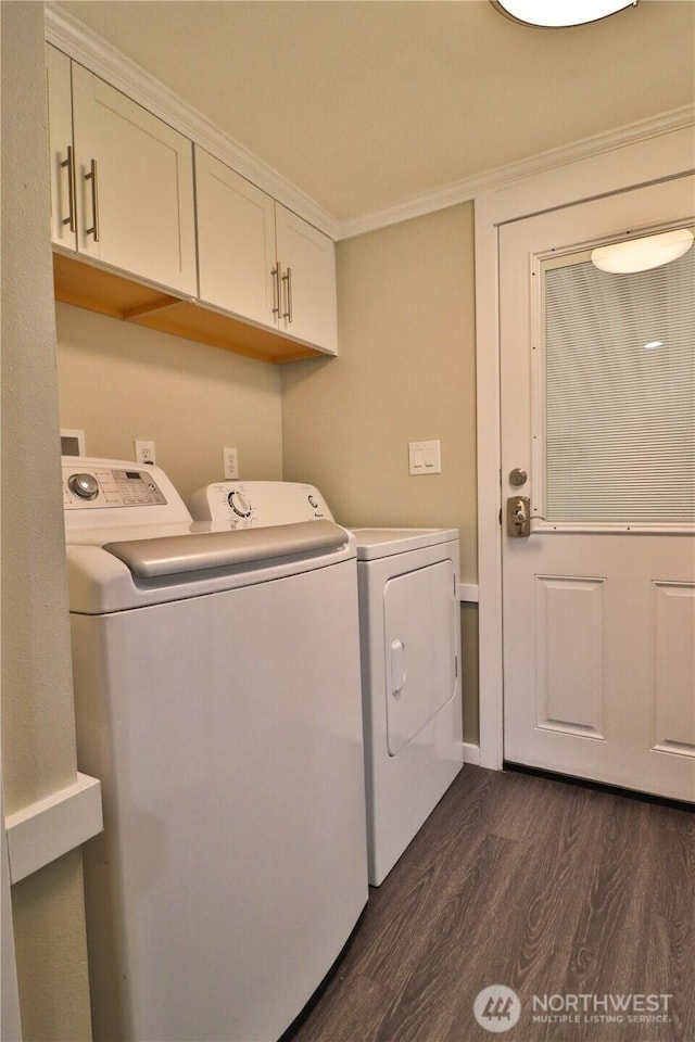 laundry area with ornamental molding, dark wood-style floors, cabinet space, and washing machine and clothes dryer