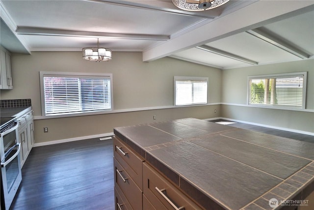 kitchen with an inviting chandelier, lofted ceiling with beams, dark wood finished floors, and dark countertops