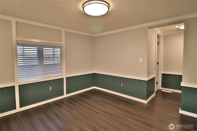 empty room featuring crown molding, baseboards, and wood finished floors