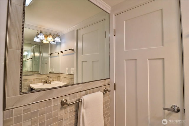 bathroom with crown molding, backsplash, and a sink