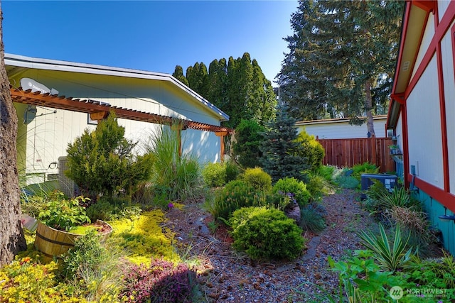 view of yard with fence and central AC unit