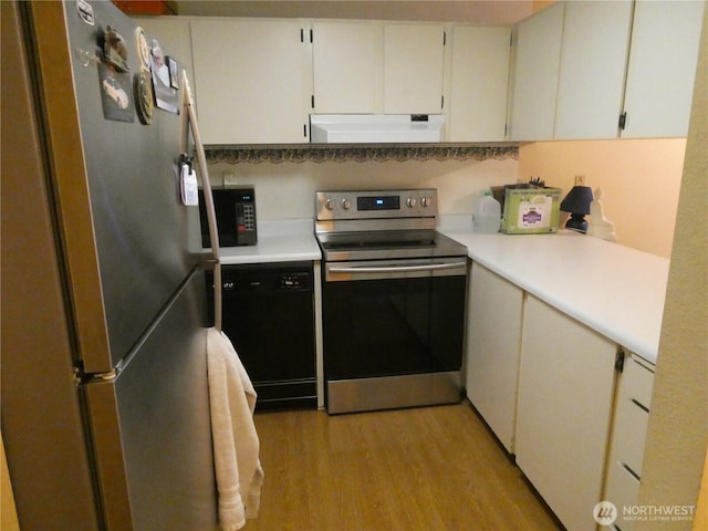 kitchen featuring light countertops, light wood finished floors, under cabinet range hood, and stainless steel appliances