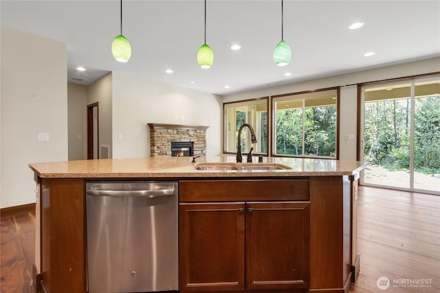 kitchen featuring stainless steel dishwasher, open floor plan, a wealth of natural light, and a sink