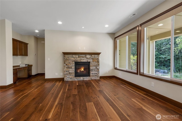 unfurnished living room featuring recessed lighting, baseboards, dark wood finished floors, and visible vents