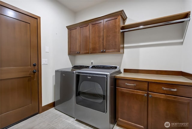 washroom featuring cabinet space, independent washer and dryer, and baseboards