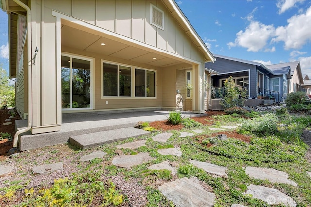 back of property with board and batten siding and a patio area