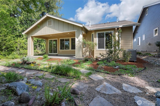 rear view of property with central air condition unit and board and batten siding