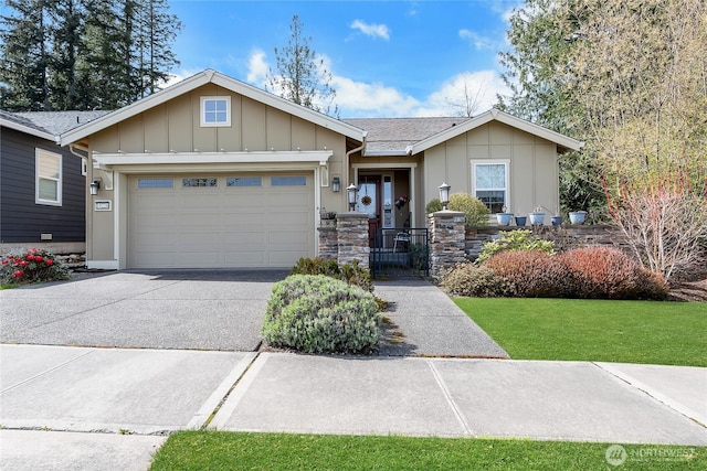 view of front facade with stone siding, a garage, board and batten siding, a gate, and driveway