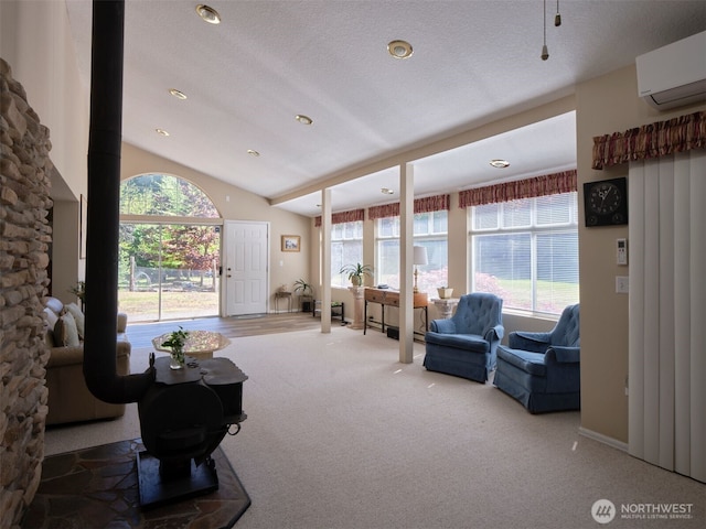597 Yale Bridge Rd, Ariel, WA 98603 - carpeted living room with a wood stove, a wall mounted air conditioner, and lofted ceiling